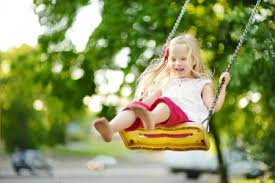 little blonde girl swinging on swing